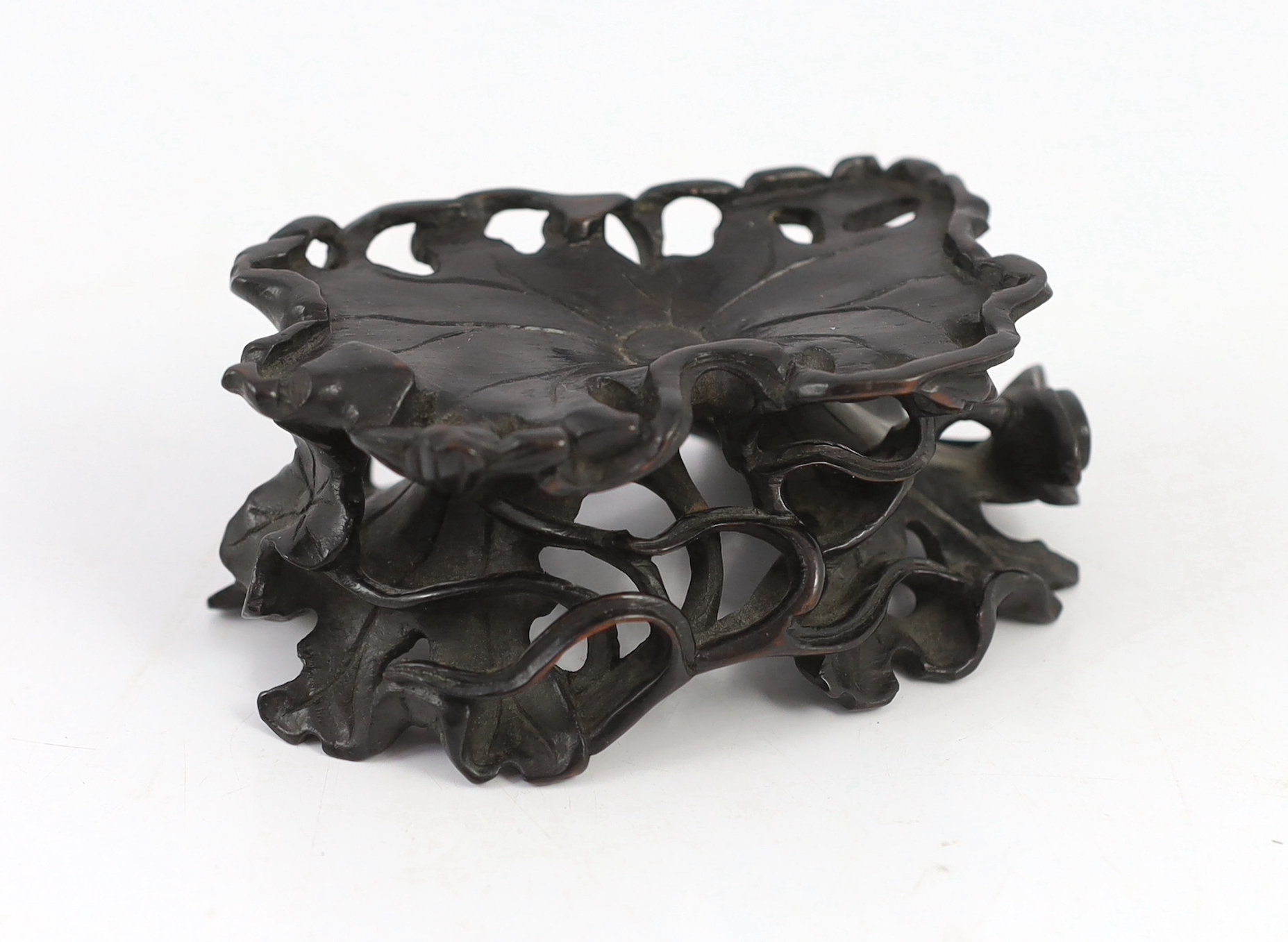 A Chinese carved wood ‘lotus’ stand and a Chinese huanghuali ‘dragon’ stand, Qing dynasty